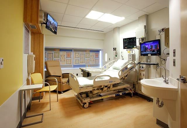 a patient room in Zayed Tower with a bed, sink and TV